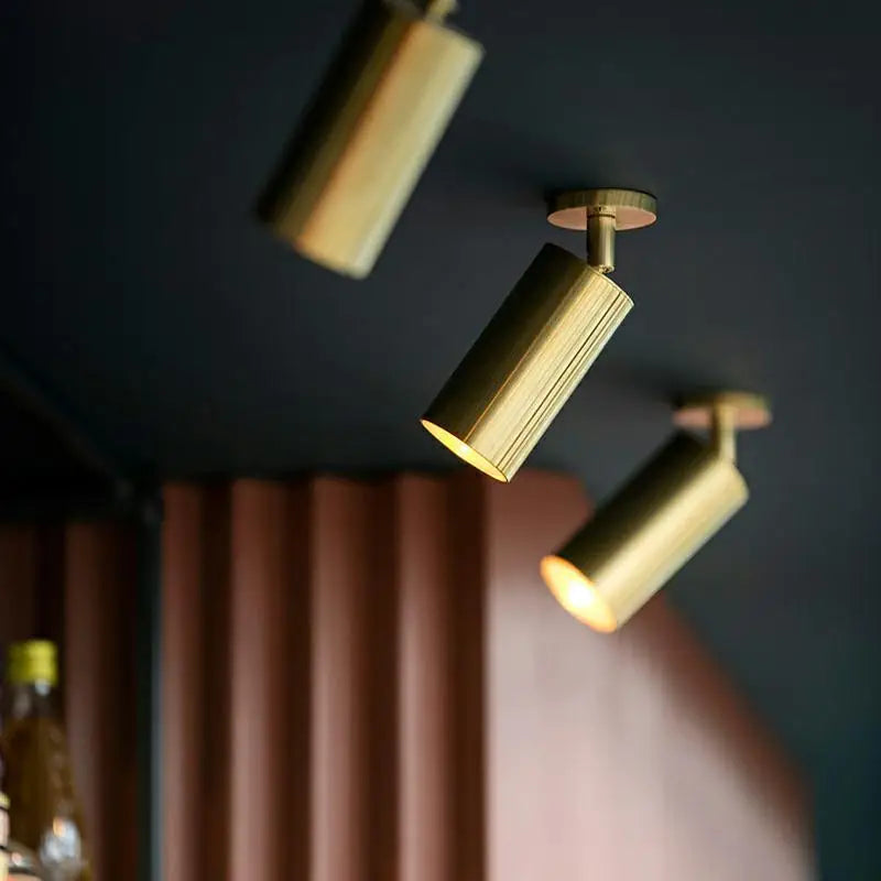 Lámpara colgante nórdica Gylden en aluminio dorado en conjunto de 3 luces sobre pared azul