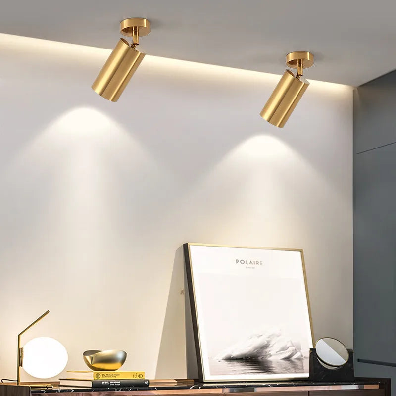Lámpara colgante nórdica Gylden en aluminio dorado iluminando cuadros decorativos