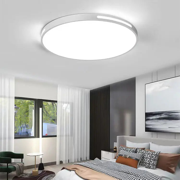 Lámpara de techo LED circular Aura de diseño moderno en dormitorio con paredes blancas